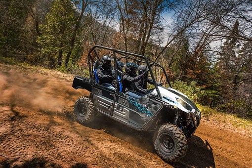 Side angle of a person and passengers driving a side x side off-road. opens in a new window