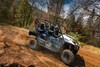 Side angle of a person and passengers driving a side x side off-road.
