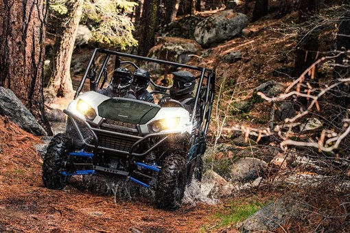 Front angle of a person and passengers driving a side x side off-road. opens in a new window