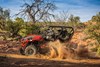 Side angle of a person and passengers driving a side x side off-road.