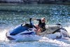 Side angle of a person on a personal watercraft on the water.