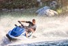 Front angle of a person on a personal watercraft on the water.