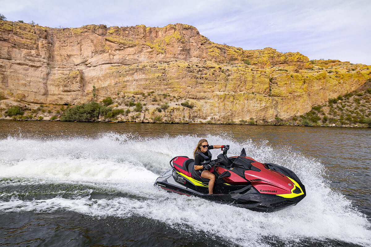 Side angle of a person riding a personal watercraft on the water.