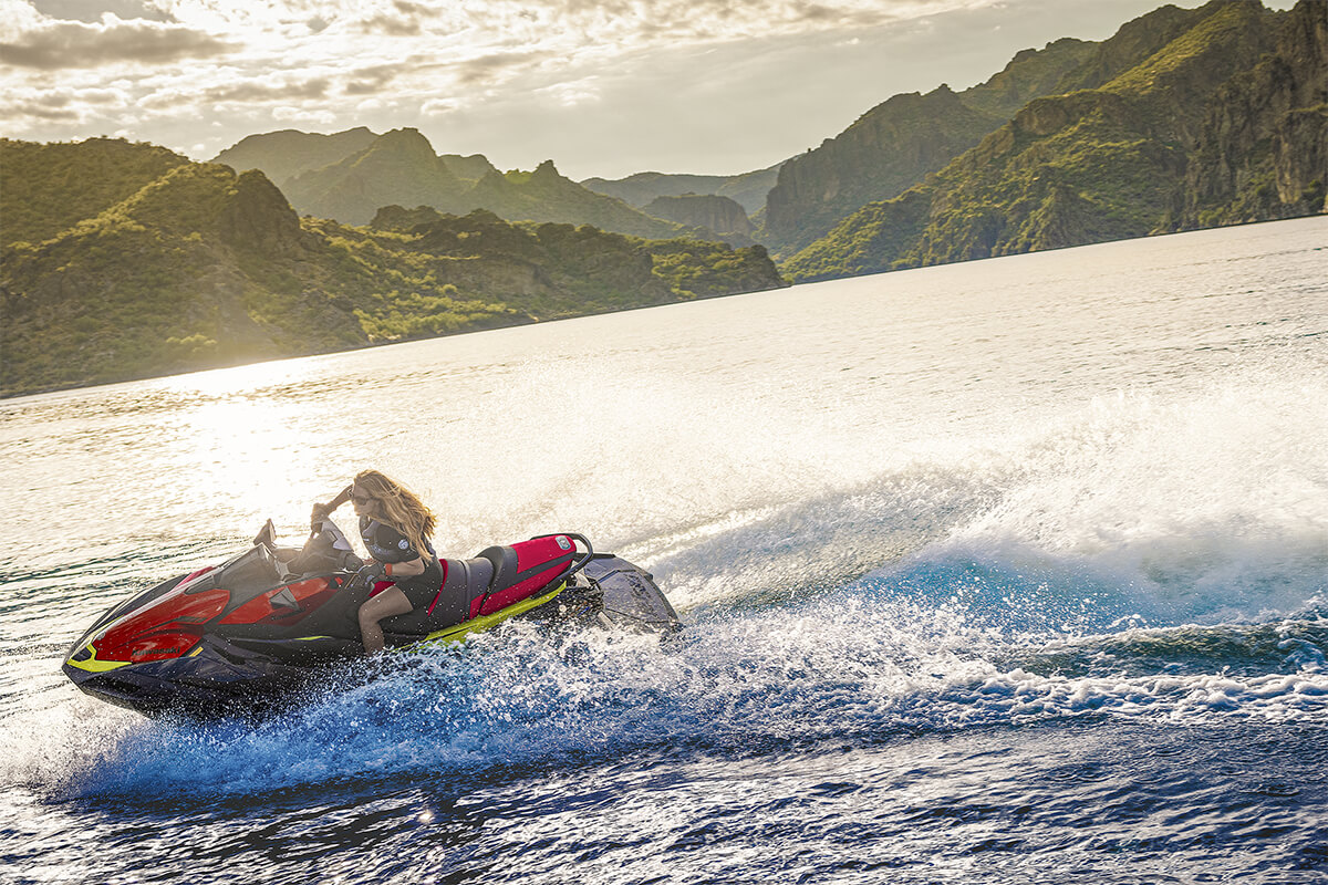 Profile angle of a person riding a personal watercraft on the water.