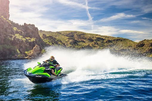 Three-quarter front angle of a person on a personal watercraft on the water. opens in a new window