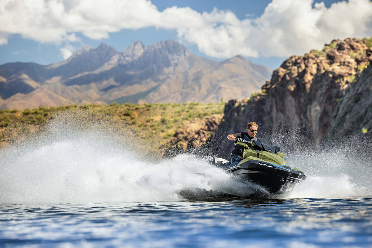 Three-quarter front angle of a person riding a personal watercraft on the water.