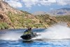 Three-quarter front angle of a person on a personal watercraft on the water.