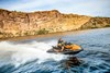 Profile angle of a person riding a personal watercraft on the water.