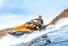 Side angle of a person turning on a personal watercraft on the water.
