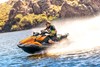 Side angle of a person on a personal watercraft on the water.