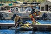 Three-quarter front angle of a personal watercraft parked next to a dock.