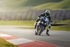 Front angle of a person on a motorcycle preparing for a turn on a track.