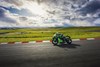 Side angle of a person on a motorcycle turning on a track.