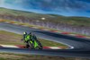 Three-quarter front angle of a person on a motorcycle turning on a track.