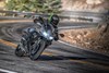 Front angle of a person riding a motorcycle on a winding road.