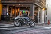 Side angle of a person riding a motorcycle in the city.