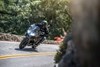 Front angle of a person riding a motorcycle on a road.