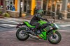 Side angle of a person riding a motorcycle in the city.