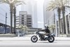 Profile angle of a person riding a motorcycle through a city.