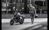 Front angle of a person next to a motorcycle.
