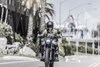 Front angle of a person riding a motorcycle on a street.