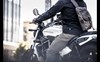 Three-quarter rear angle of a person riding a motorcycle.