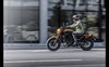 Side angle of a person riding a motorcycle in the city.