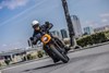 Front angle of a person riding a motorcycle on a city street.