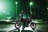 Profile angle of a person parked on a motorcycle on a street.