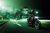 Front angle of a person riding a motorcycle on a city street.