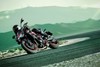 Three-quarter front angle of a person riding a motorcycle on a racetrack.