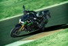 Three-quarter front angle of a person riding a motorcycle on a racetrack.