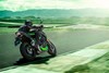 Three-quarter rear angle of a person riding a motorcycle on a racetrack. 