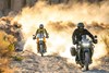 Front angle of two people riding motorcycles on an off-road trail.