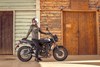 Profile angle of a person on a parked motorcycle.