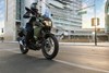 Three-quarter front angle of a person riding a motorcycle on a road.