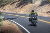 Front angle of a person riding a motorcycle on a road.