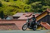 Three-quarter front angle of a person riding a motorcycle on a road.