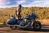 Profile angle of a person next to a parked motorcycle.