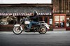 Profile angle of a person riding a motorcycle on a street.