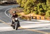 Front angle of a person riding a motorcycle on a street.
