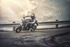 Three-quarter front angle of a person riding a motorcycle around a bend.