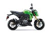 Side angle of a green motorcycle staged in a white studio background.