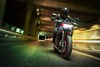 Front angle of a person riding a motorcycle on a street.