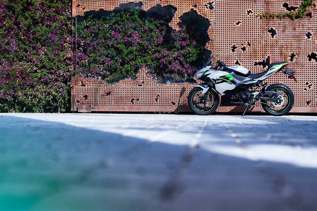 Side angle of a motorcycle staged near a wall.
