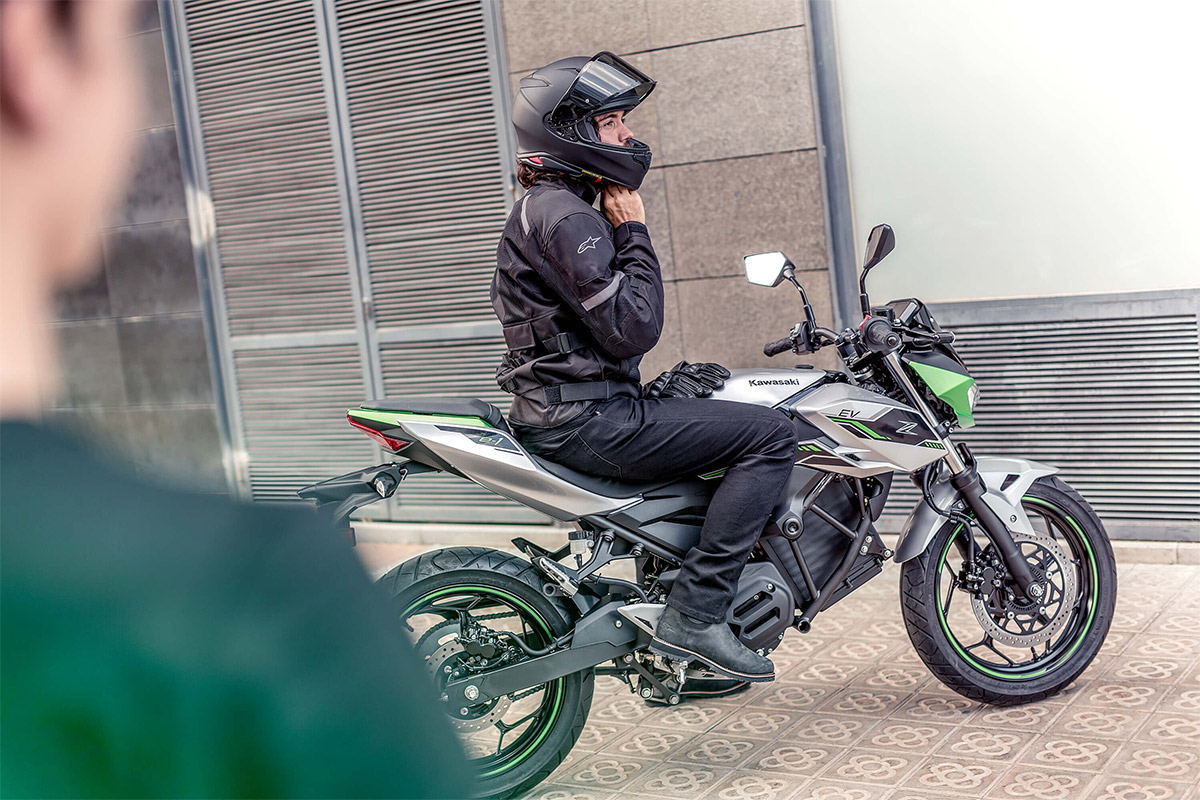 Side angle of a person on a parked motorcycle.