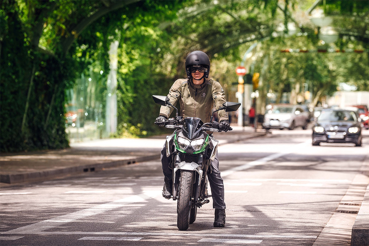 Front angle of a person on a motorcycle on a street.