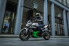 Profile angle of a person riding a motorcycle on a city street.