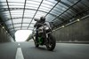 Front angle of a person riding a motorcycle on a street.