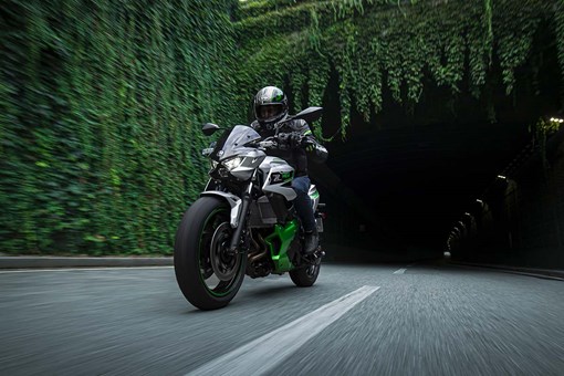 Front angle of a person riding a motorcycle out of a tunnel. opens in a new window